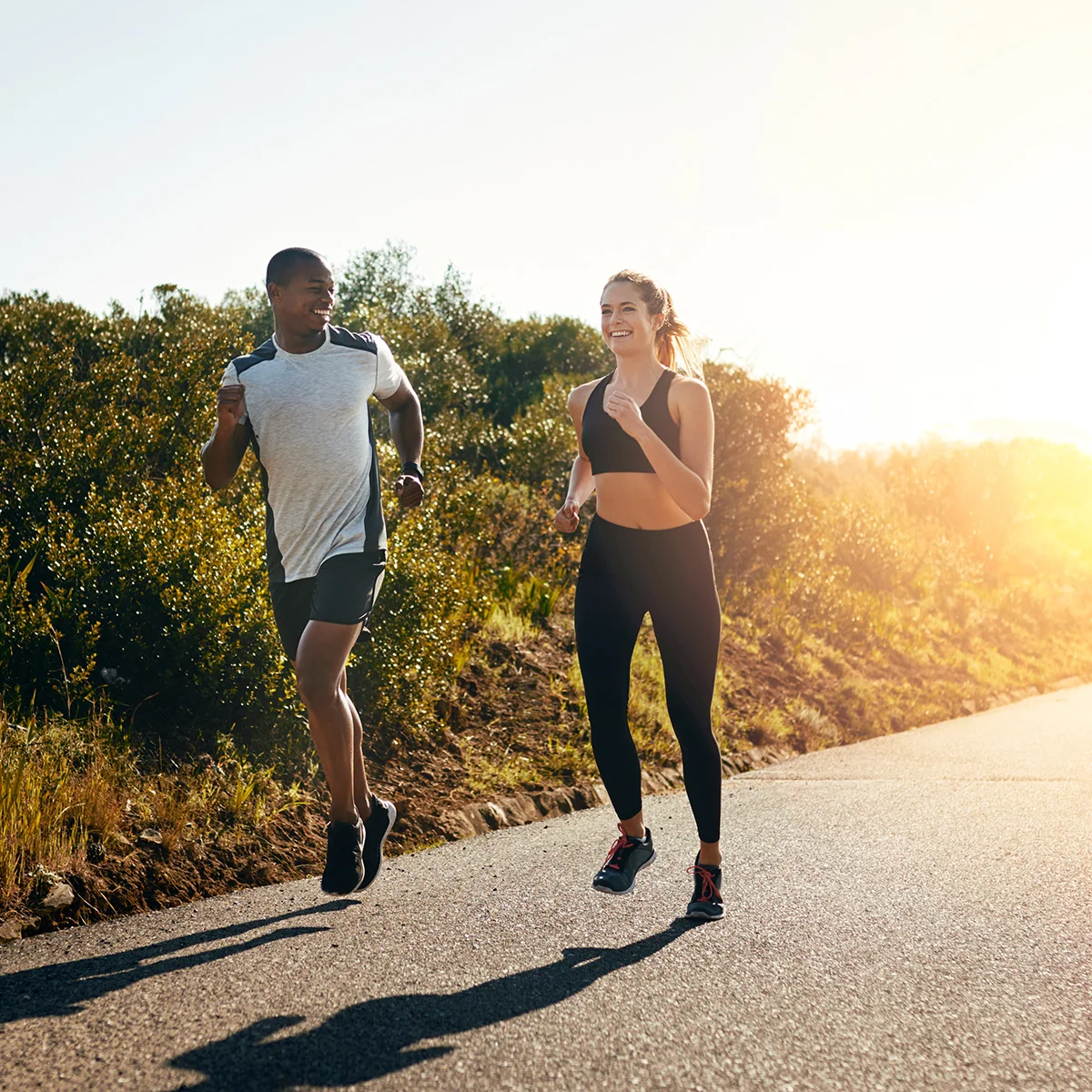 A young man and woman go for a run. It's sunset and they're happy they're participating in the aftercare support program at Sheridan Grove Recovery.