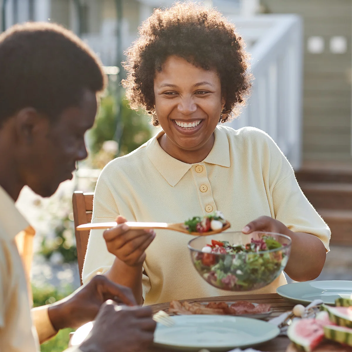 A man and woman sit outside and eat a beautiful salad together. They've benefited from medication-assisted treatment at Sheridan Grove Recovery.