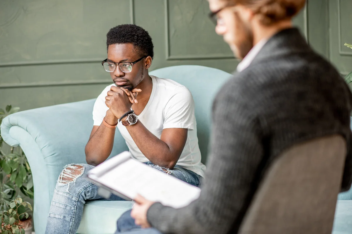 A man sits with a contemplative expression on his face during his therapy session at Sheridan Grove Recovery.