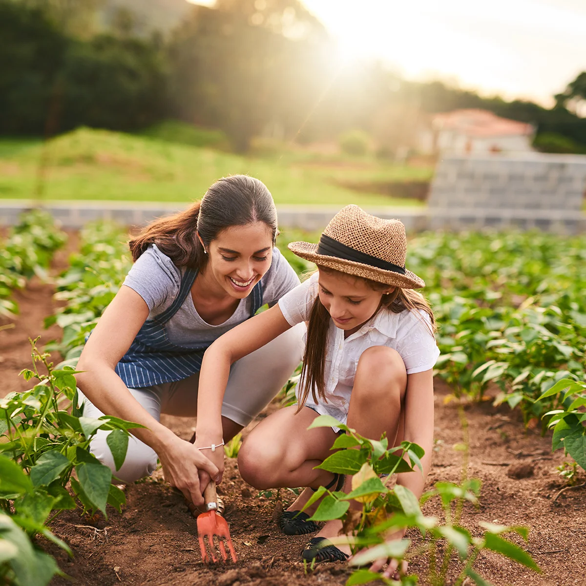 A woman and a young girl are gardening. The woman is happy she's able to spend time with her daughter after participating in therapy programs at Sheridan Grove Recovery.