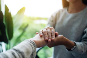 Woman holding another person's hands in support